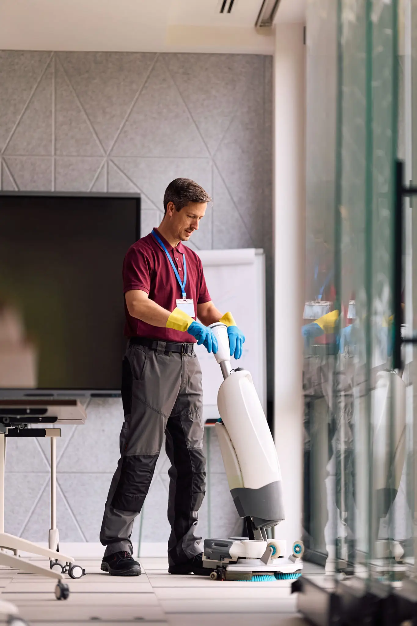 Janitor polishing office floors while using professional cleaning machine.